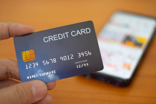 The Hands holding plastic credit card and using Mobile Phone for online shopping. Online shopping concept