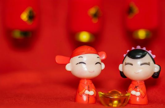 Chinese New Year decoration on a red background Chinese Couple Figure Model wish for a Luck  and lump of gold and a Chinese Word on Lantern said Luck