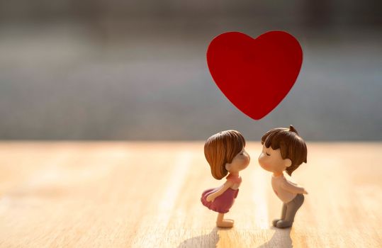 The Miniature Couple dolls Boy and Girl Romantic Kiss with Red Heart on above for Background for valentine's Day Concept