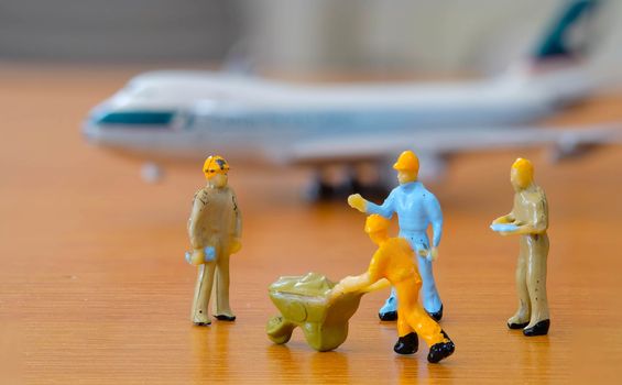 Airplane engineer, airport worker, aircraft people working in repairing the runway and Fix and checking the airplane. Many level of miniature company employee and employer figure as Airplane flight concept