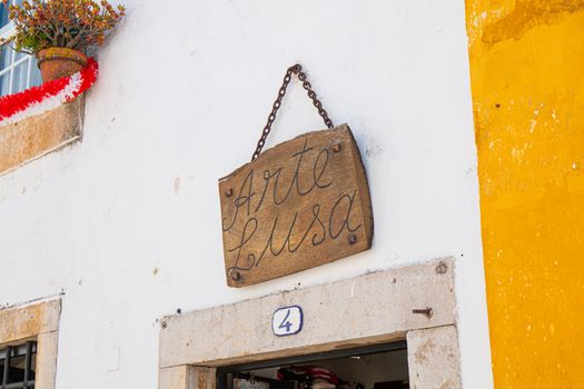 Obidos, Portugal - April 12, 2019: facade of a small souvenir shop Arte Lusa (Portuguese art) in the historic city center on a spring day