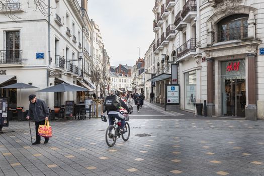 Tours, France - February 8, 2020: Street ambiance and architecture in a pedestrian street in the historic city center where people walk on a winter day on a winter day