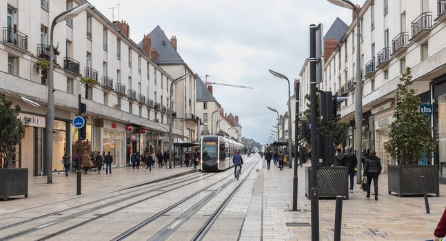 Tours, France - February 8, 2020: Electric tram rolling in a pedestrian street in the historic city center on a winter day