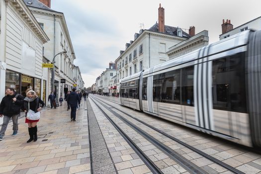 Tours, France - February 8, 2020: Electric tram rolling in a pedestrian street in the historic city center on a winter day