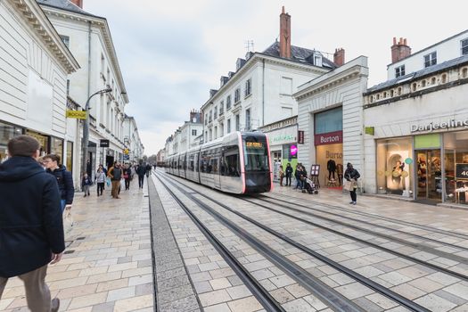 Tours, France - February 8, 2020: Electric tram rolling in a pedestrian street in the historic city center on a winter day