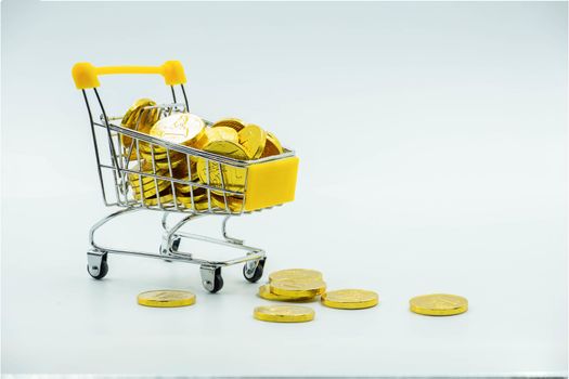 The Shopping cart and Gold coins Isolated on White background