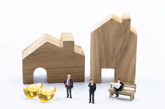 miniature business man with the Gold in front of the building and Land isolate on white background Investiment  Concept