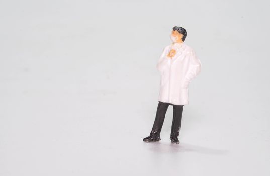 the miniature fifure doll doctor wearing face mask isolated on white background