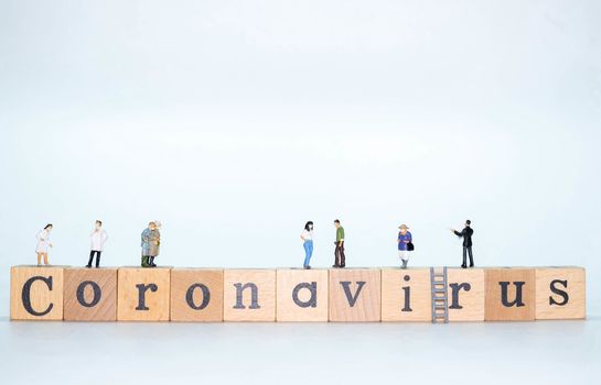 Wooden Alphabet word Coronavirus with miniature figure doll of people and doctoe nurse wearing face mask isolate on white background