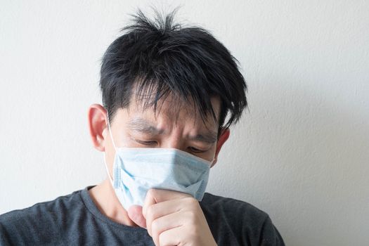 The Face of Sick Asian Chinese Man Wearing Face Mask feeling sick headache and  cough because of  Coronavirus Covid-19  Isolate on White Background