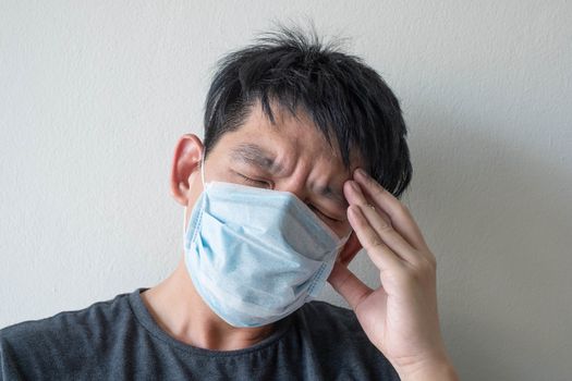 The Face of Sick Asian Chinese Man Wearing Face Mask feeling sick headache and  cough because of  Coronavirus Covid-19  Isolate on White Background
