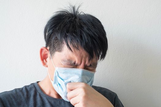 The Face of Sick Asian Chinese Man Wearing Face Mask feeling sick headache and  cough because of  Coronavirus Covid-19  Isolate on White Background