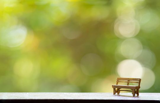 The wooden bench with Green Tree Bokeh in the Background for wallpaper