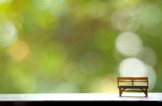 The wooden bench with Green Tree Bokeh in the Background for wallpaper