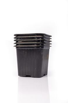 used black plastic gardening bucket waiting for spring on white background in studio