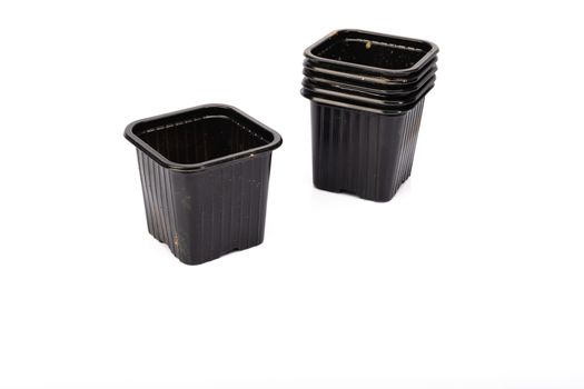 used black plastic gardening bucket waiting for spring on white background in studio