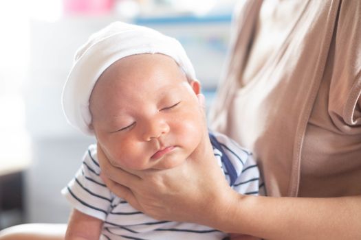 Soft focus photo of mother, mom using hand Hold baby to help a baby newborn infant belch burping after breastfeeding milk to heal gas pain or indigestion