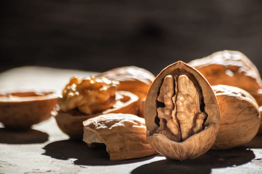 still life with Walnut kernels and whole walnuts on rustic old wooden table.