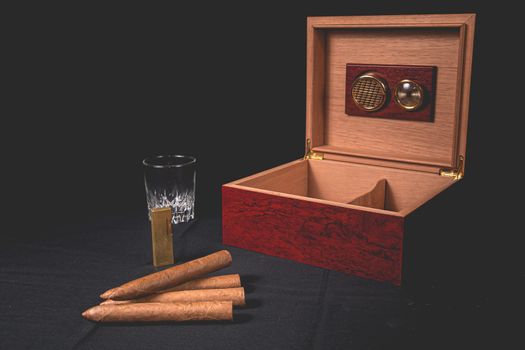 Cigar box on black background and gold lighter