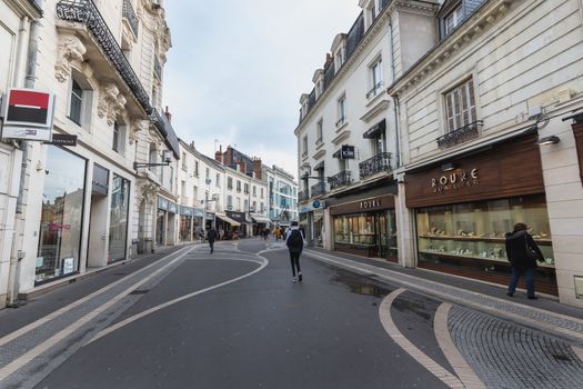 Tours, France - February 8, 2020: Street ambiance and architecture in a pedestrian street in the historic city center where people walk on a winter day on a winter day