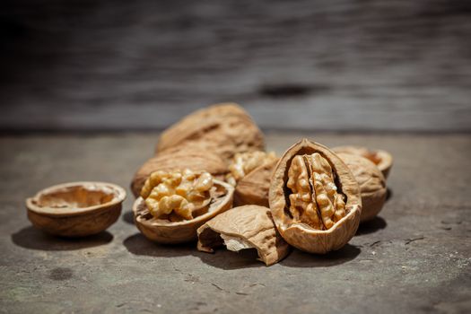 still life with Walnut kernels and whole walnuts on rustic old wooden table.