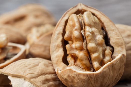 still life with Walnut kernels and whole walnuts on rustic old wooden table.