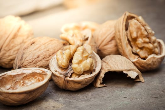 still life with Walnut kernels and whole walnuts on rustic old wooden table.