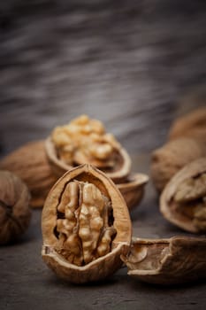 still life with Walnut kernels and whole walnuts on rustic old wooden table.