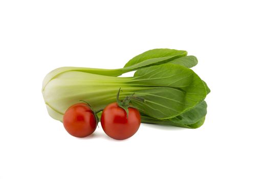 Fresh pak choi cabbage or chinese cabbage and cherry tomato twig isolated on white background