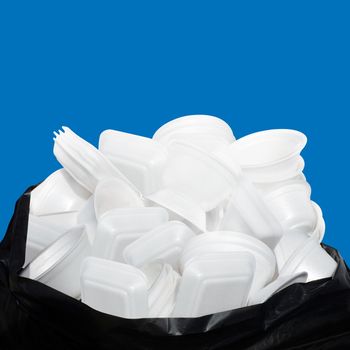 Waste Garbage foam food tray white many pile on the plastic black bag dirty isolated on blue background, Bin, Trash, Recycle, foam trays garbage isolated on blue background