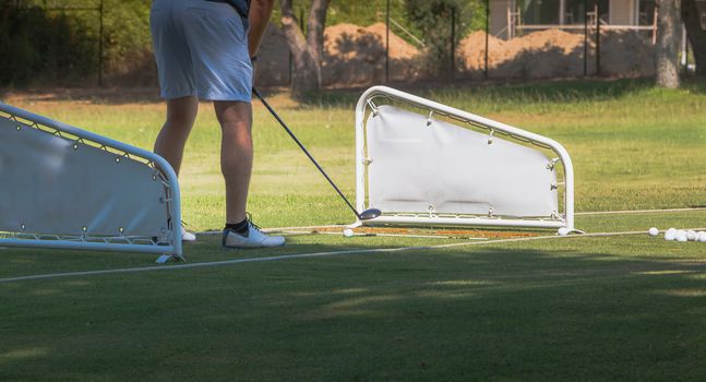 golf player making a swing with a golf  fairway wood course on the golf practice