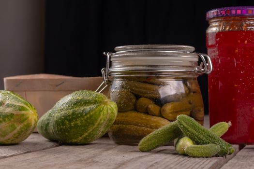 cucumber tomatoes cherry tomato jam canned corinichons on wooden background in studio