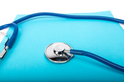 medical record and blue stethoscope close-up on white background in studio