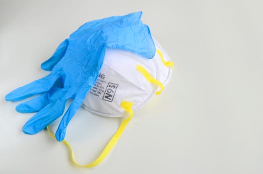 N95 respirator with medical glove on grey background for covid-19 Coronavirus prevention concept.