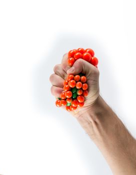 Male hand squeezing stress ball over plain background