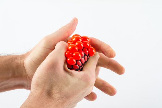 Male hands squeezing stress ball over plain background