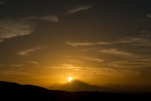 Sun is setting over Sahara desert mountains