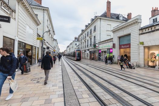 Tours, France - February 8, 2020: Electric tram rolling in a pedestrian street in the historic city center on a winter day