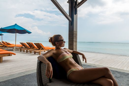 Young woman relaxing at the beach bar in Indonesia