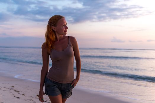 Young woman enjoying sunset view at tropical island beach