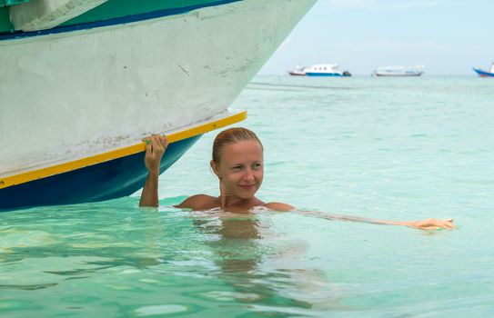 Woman at tropical island beach - near traditional boat