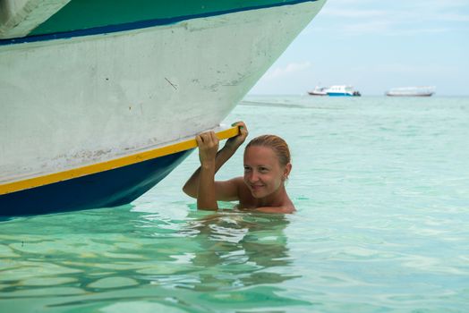 Woman at tropical island beach - near traditional boat