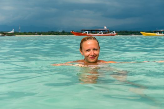Woman at tropical island beach swimming smiling