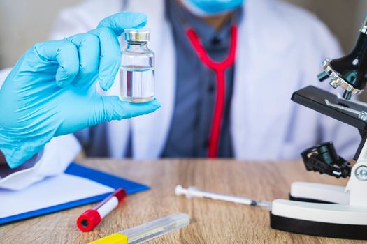 Close up The doctor's hand holds a bottle of vaccination pills. For the treatment of the virus that is being infected or infectious concept with blur background