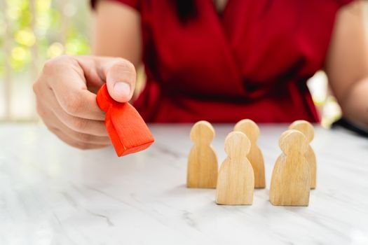 Figure in human resource management concept. The red wood figure was picked out of its group. Red Wood figure like who is selected from the candidate, or choose the most dominant in the team