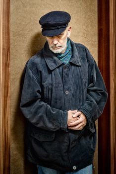 Portrait of a mature man with a white beard and a cap on the head. He could be a sailor, a worker, a docker, or even a gangster or a thug. He has a penetrating gaze.