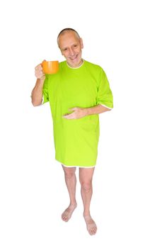 A happy man in green nightdress, smiling and hanging an orange cup of coffee