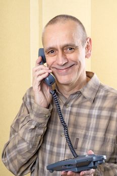 Happy smiling man speaking on phone at home