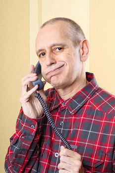 Annoyed man listening a boring conversation on phone