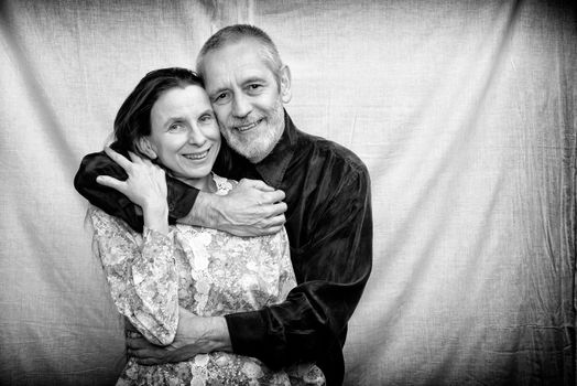 Happy mature man and woman smiling for S. Valentine's day or anniversary and embracing each other. Black and white photo.